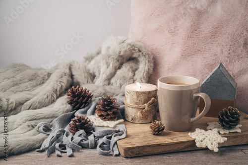 Hygge Scandinavian style concept with coffee cup, candles and pine corn photo