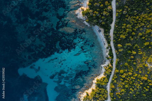 Fototapeta Naklejka Na Ścianę i Meble -  Aerial view of an amazing rocky and green coast bathed by a transparent and turquoise sea. Sardinia, Italy..