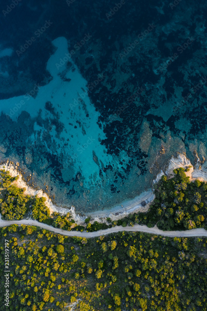 Obraz premium Aerial view of an amazing rocky and green coast bathed by a transparent and turquoise sea. Sardinia, Italy..