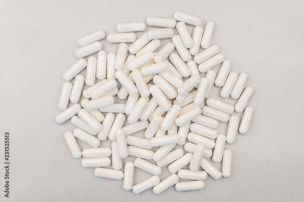 many white pills on gray background many white pills on gray background