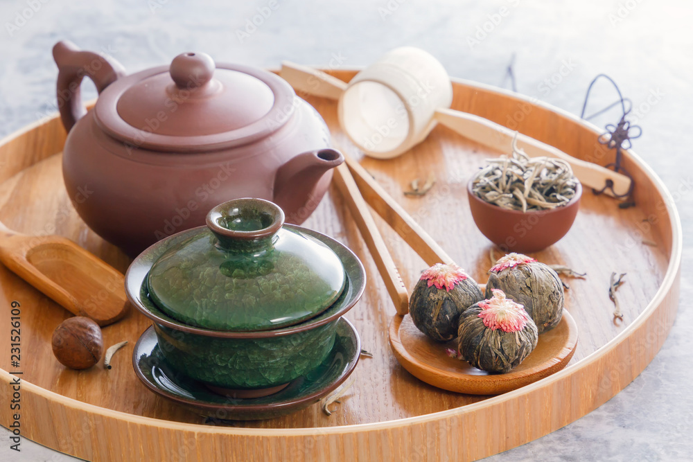 Green tea and tea ceremony attributes - ceramic teapot, cups, strainer,  chopsticks and tweezers placed on a wooden tray Stock Photo | Adobe Stock