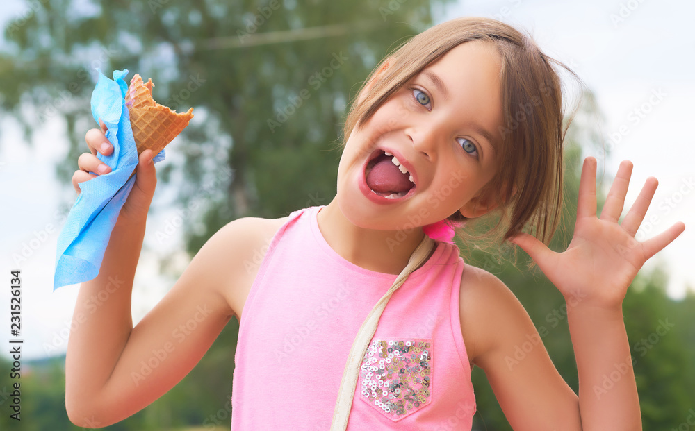 Pretty little girl eating licking big ice cream in waffles cone happy laughing on nature background Pretty little girl eating licking big ice cream in waffles cone happy laughing on nature background