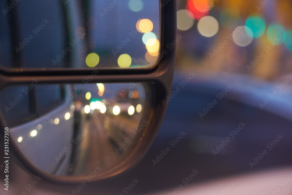 reflection of the road in the mirror. in the evening by car. road with bokeh lights.