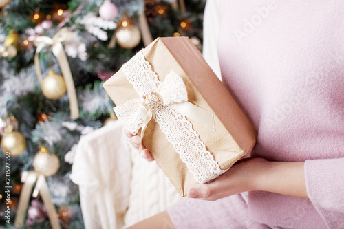 Сhild's hands holding gift box. Christmas, hew year, birthday concept. Festive background with bokeh and sunlight. Magic fairy tale