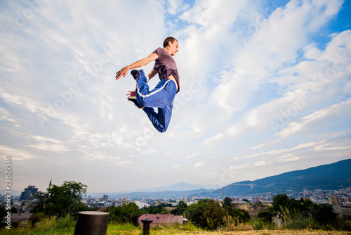 Sportive man make parkour tricks while jumping