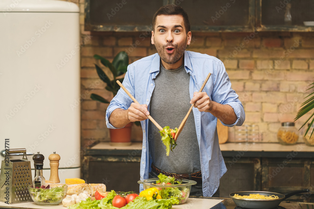 Man cooking healthy simple vegetarian food at home in the kitchen sunny day. Healthy food concept. Man cooking healthy simple vegetarian food at home in the kitchen sunny day. Healthy food concept.