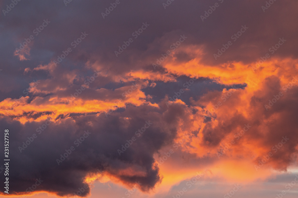 Fototapeta premium Dramatic sunset sky with orange colored clouds.