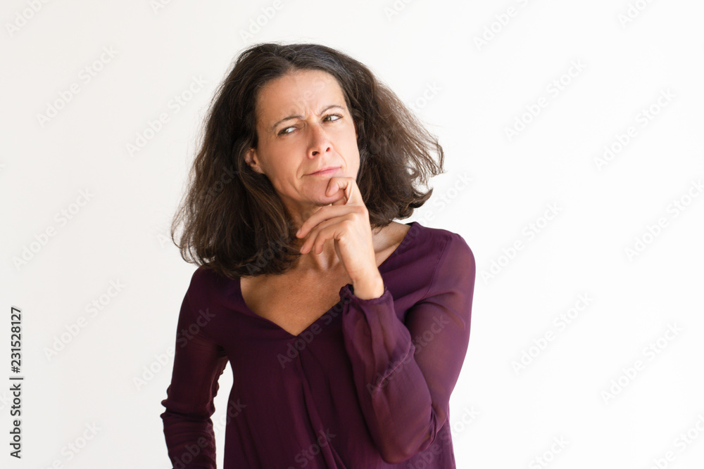 Middle aged woman suspects something strange. Thoughtful Caucasian woman with finger on chin. Isolated on white. Suspecting concept Middle aged woman suspects something strange. Thoughtful Caucasian woman with finger on chin. Isolated on white. Suspecting concept