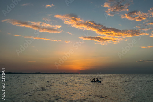 People on a raft are watching the sunset over the sea in Zadar, Croatia photo