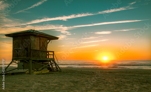 Sunrise Sunset with lifeguard stand on thebeach