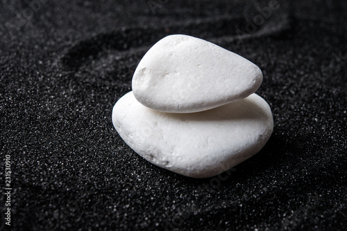 Canvas Print White stones on black sand background