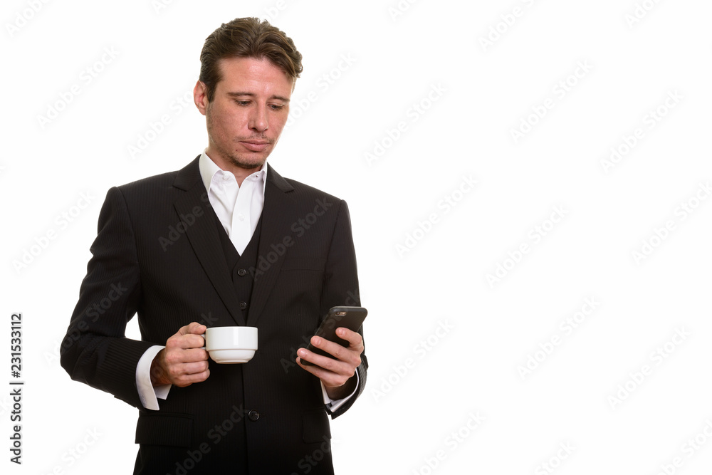 Handsome Caucasian businessman using mobile phone while holding Handsome Caucasian businessman using mobile phone while holding