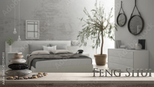 Wooden vintage table shelf with pebble balance and 3d letters making the word feng shui over blurred bedroom with window, chest of drawer and big olive tree, zen concept interior design