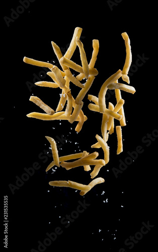 French fries with salt explode flying in the air isolated on black background,Stop motion