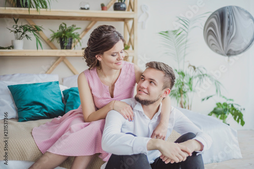 a couple in love, a guy and a girl are sitting in an apartment, hugging and looking at each other