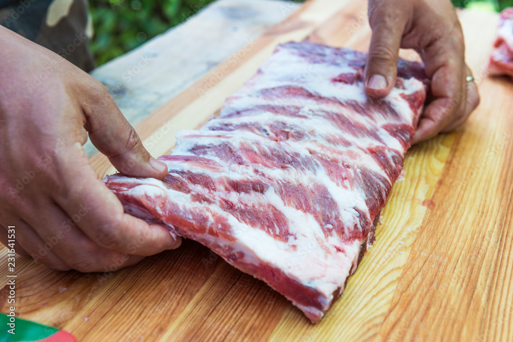 Butcher prepares pork ribs for cooking