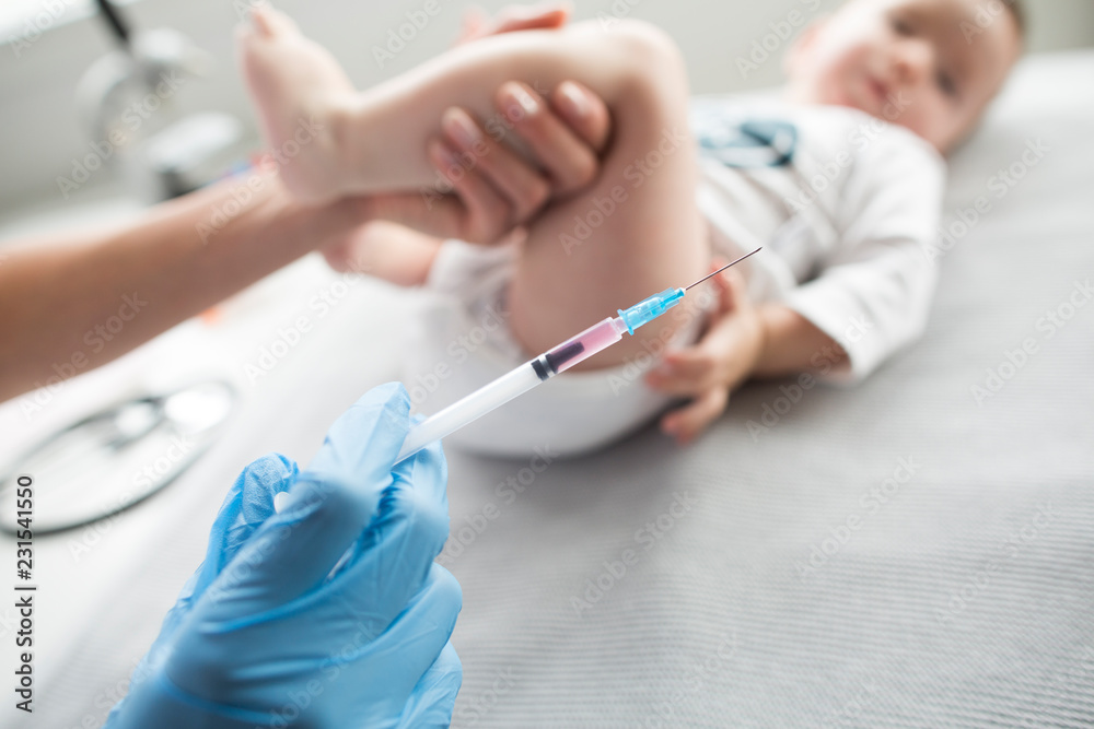 Young, female doctor giving an injection a baby boy. Young, female doctor giving an injection a baby boy.