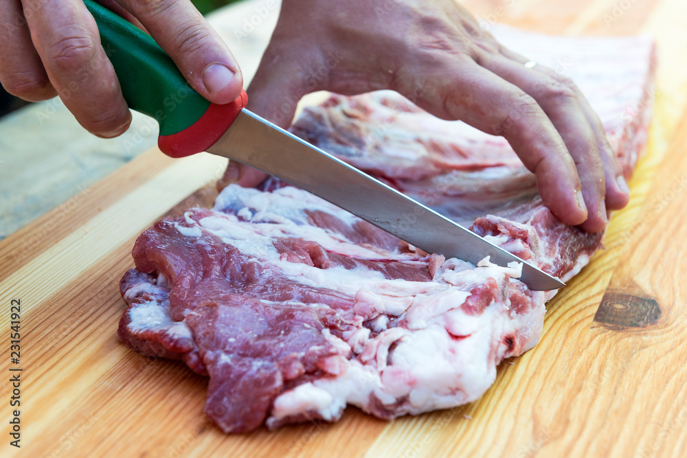 Butcher prepares pork ribs for cooking