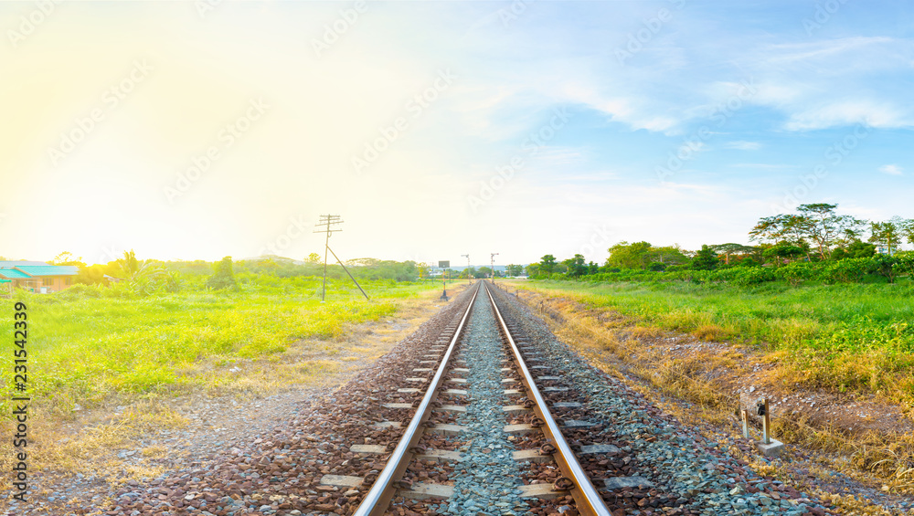 railway tracks in a rural area with bright moring sunrise, panorama view