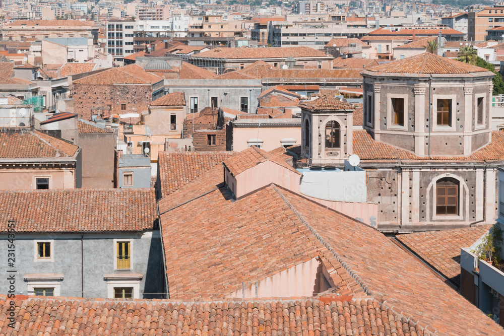 Detail of skyline view of Catania old town featuring ochre, brown and yellow roofs and churches. Sicily, Italy. Mediterranean urban background. 
