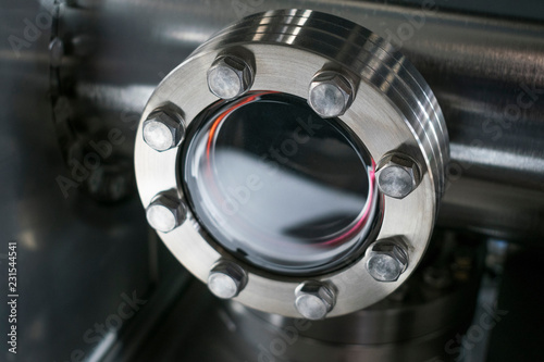 Detail of vacuum equipment with steel flanges bolted to the vessel in laboratory or industrial environment. Abstract industrial or technology background. photo