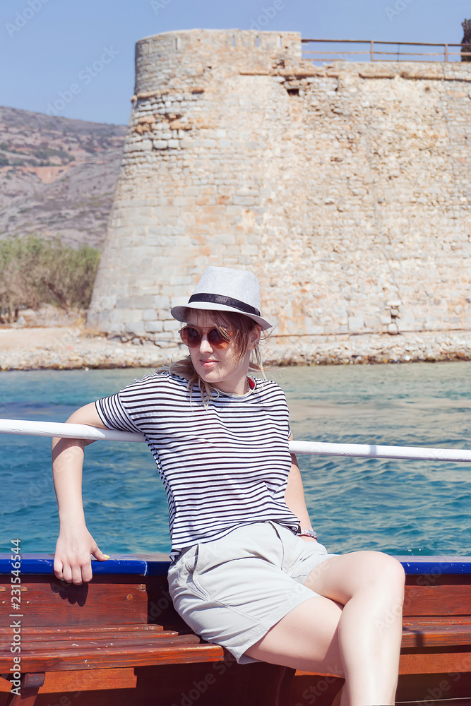 Young woman on a boat traveling to the ancient fortress