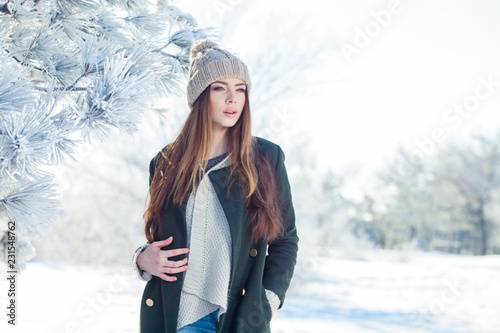 Beautiful winter portrait of young woman in the snowy scenery
