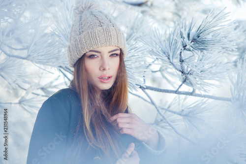 Beautiful winter portrait of young woman in the snowy scenery