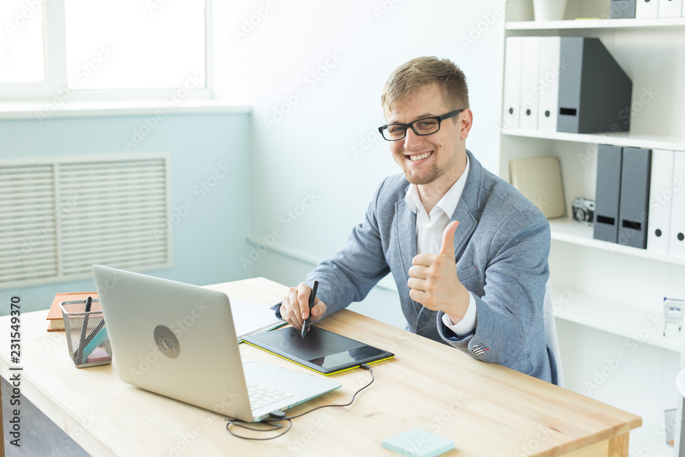 Designer, artist and web design concept - Portrait of young man using digital pen tablet and laptop in the office Designer, artist and web design concept - Portrait of young man using digital pen tablet and laptop in the office