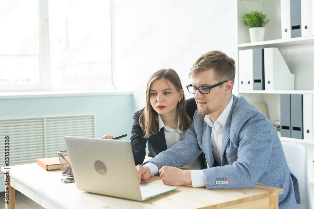 Business people, team work and office concept - Man and woman colleague sitting at table and discussing some interesting startup project. Business people, team work and office concept - Man and woman colleague sitting at table and discussing some interesting startup project.