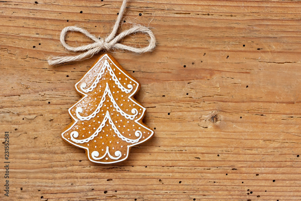 Gingerbread cookies hanging over wooden background Gingerbread cookies hanging over wooden background