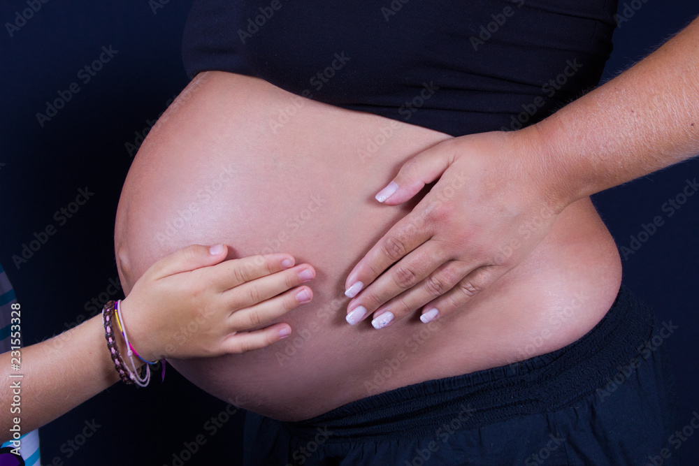 Babybauch mit Händen von Mutter und Schwester Babybauch mit Händen von Mutter und Schwester