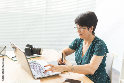 Business, web design and graphic art concept - middle-aged woman using pan sketch device