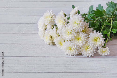 Bouquet of white chrysanthemums on a white wooden table