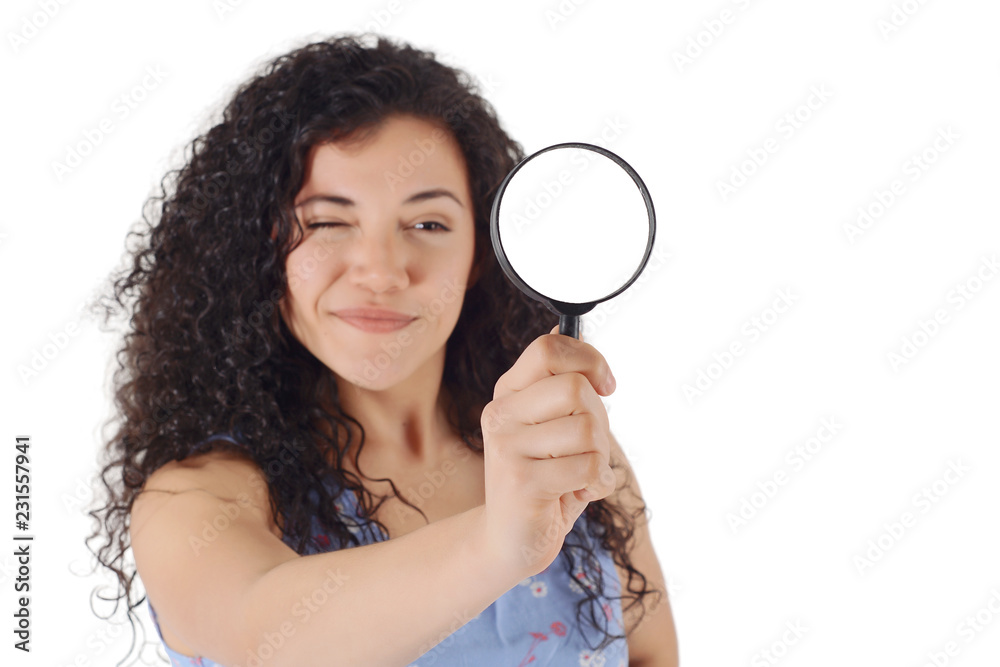 Happy smiling young woman looking through a magnifying glass Happy smiling young woman looking through a magnifying glass