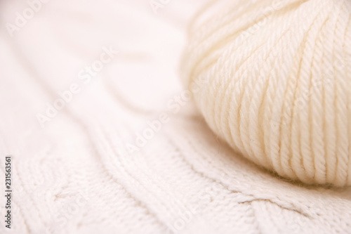 white ball of crochet thread in a white scarf, cozy white patterned scarf