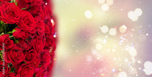 Bouquet of fresh dark red rose buds with over bokeh fesive background banner