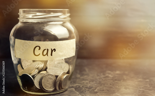 Glass jar with coins and the inscription "Car". The concept of accumulation of money for a auto. Saving money for a dream. Buying a car. Family Financing and Budget. copy space