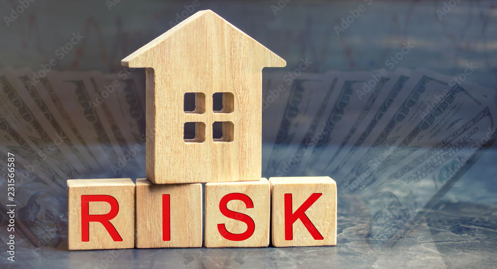 wooden house and cubes with the word risk. The concept of risk, loss of real estate. Property insurance. Loans secured by home, apartment. Financial risks, litigation. Confiscation for debt wooden house and cubes with the word risk. The concept of risk, loss of real estate. Property insurance. Loans secured by home, apartment. Financial risks, litigation. Confiscation for debt