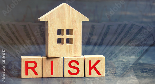 wooden house and cubes with the word risk. The concept of risk, loss of real estate. Property insurance. Loans secured by home, apartment. Financial risks, litigation. Confiscation for debt