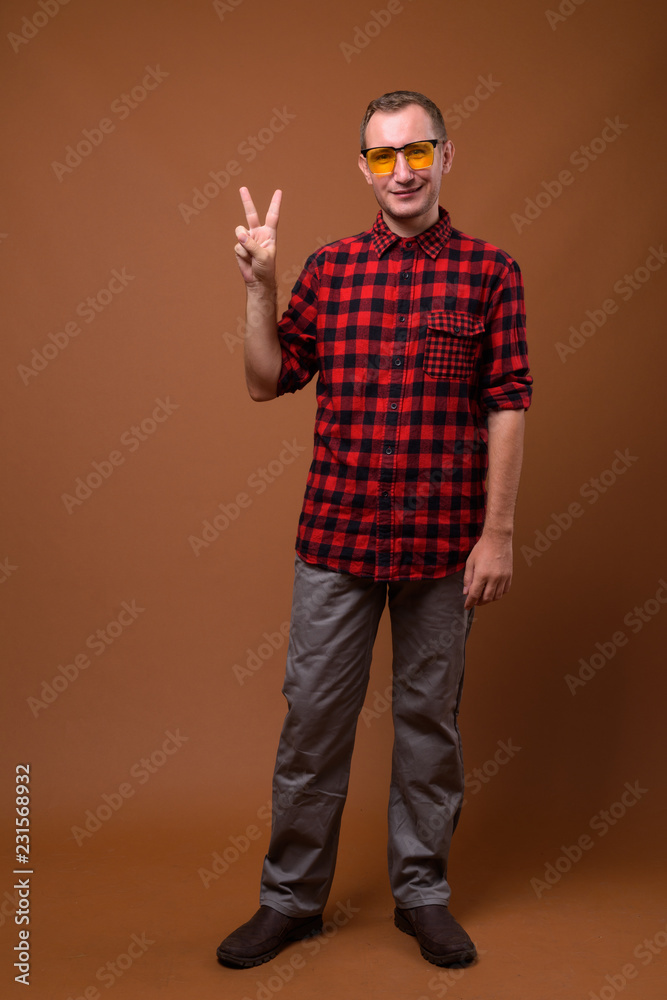 Studio shot of man against brown background Studio shot of man against brown background