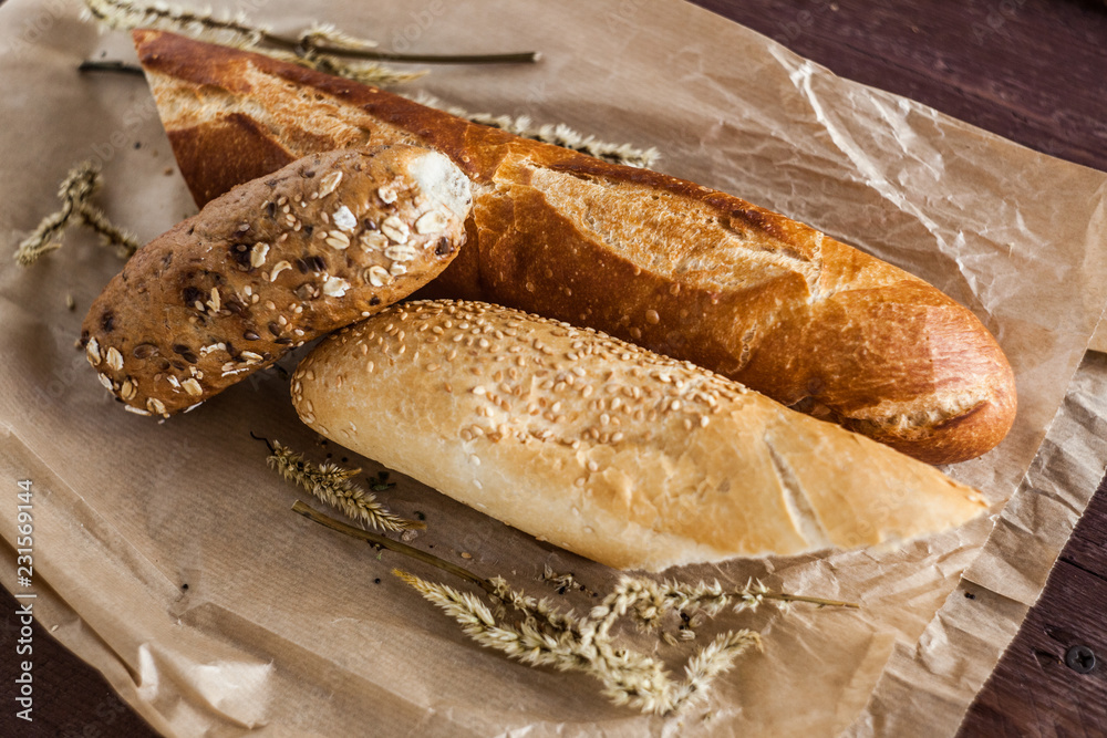 mix of different varieties of bread lying on a wooden table mix of different varieties of bread lying on a wooden table
