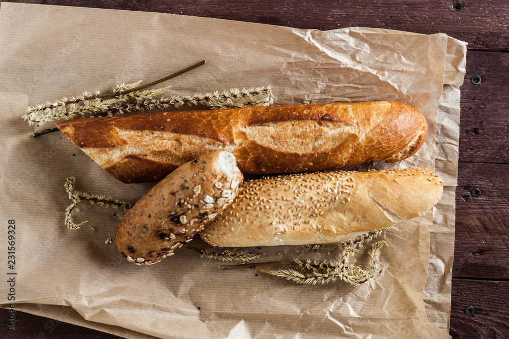 mix of different varieties of bread lying on a wooden table mix of different varieties of bread lying on a wooden table
