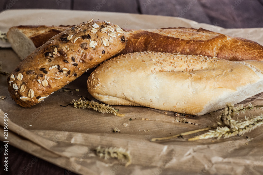 mix of different varieties of bread lying on a wooden table mix of different varieties of bread lying on a wooden table