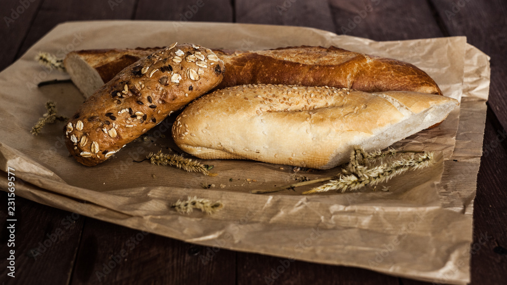 mix of different varieties of bread lying on a wooden table mix of different varieties of bread lying on a wooden table