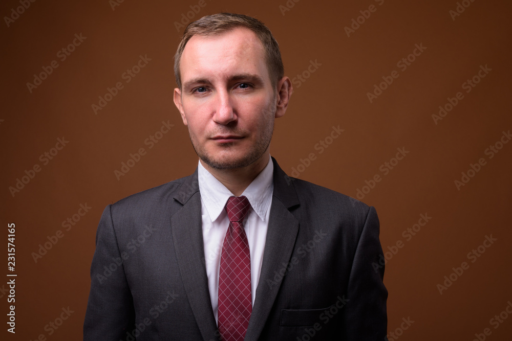 Studio shot of businessman against brown background Studio shot of businessman against brown background