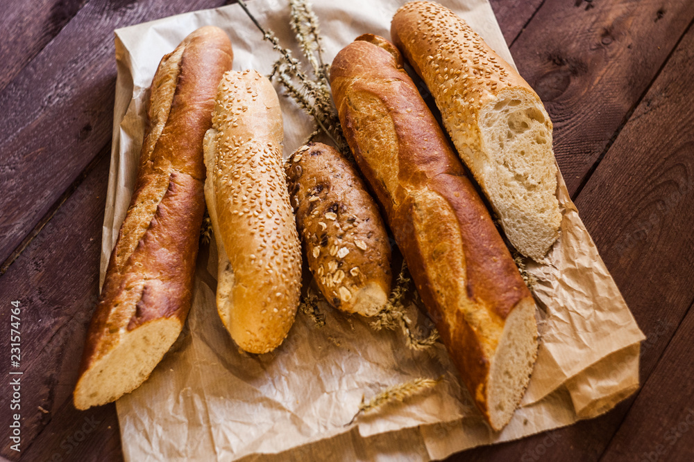 mix of sorts of baguettes on a wooden table. Bakery products.