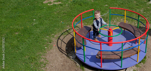 The child is riding a carousel, a view from above photo