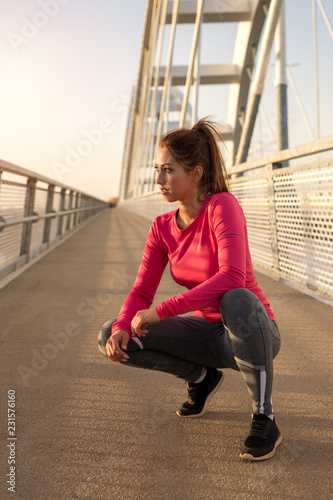 Beautiful young fit woman working out outside on a bridge © Marko