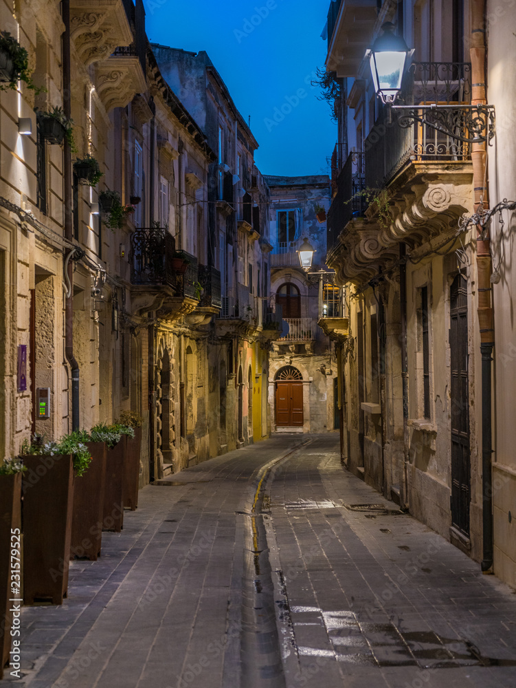 A picturesque road in Siracusa old town (Ortigia) at night. Sicily, southern Italy.